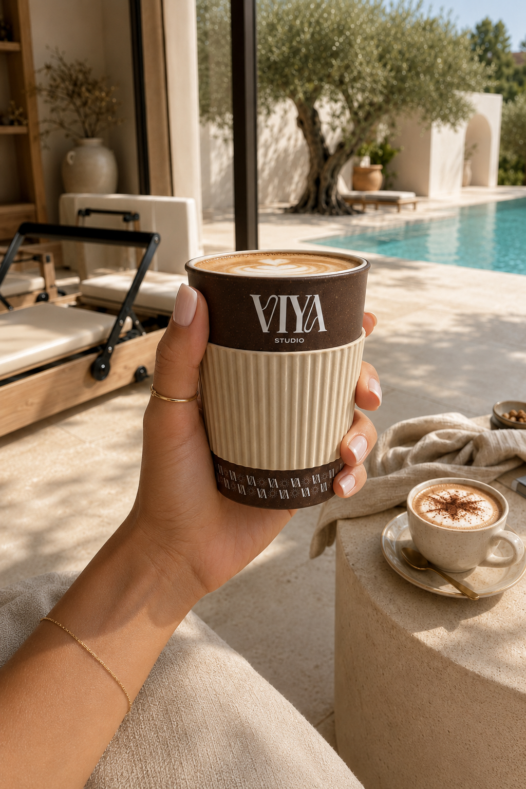 Coffee Cup Signature VIYA Studio tenue à la main, rituel café bord de piscine